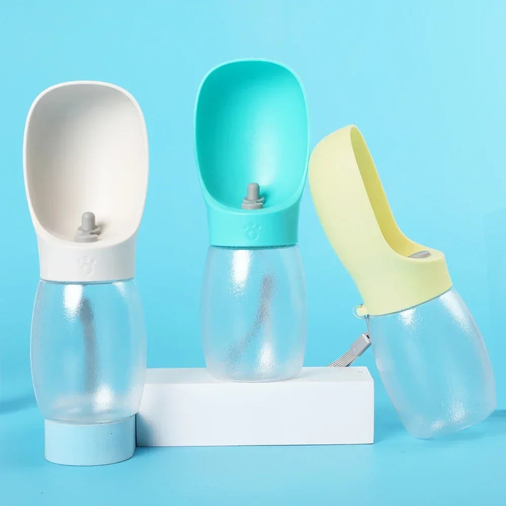 Three portable pet water bottles with built-in dispenser in pastel colors on blue background