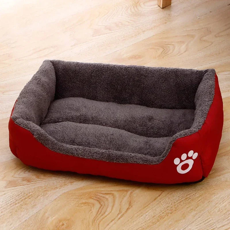 Plush red and gray rectangular pet bed with paw print design on wooden floor