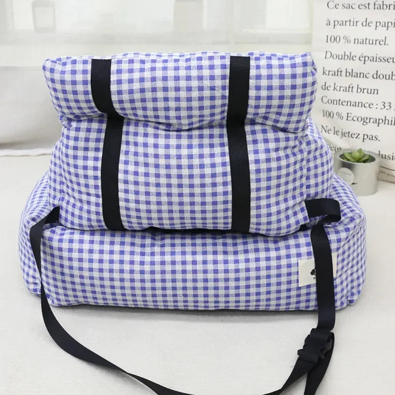Blue and white checkered portable pet bed with black straps on a light background