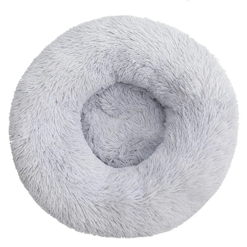 Round fluffy light gray calming pet bed with plush texture, viewed from above
