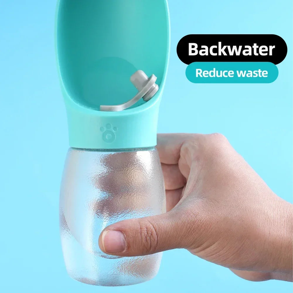 Hand holding portable dog water bottle with blue dispenser, anti-leak, backwater design
