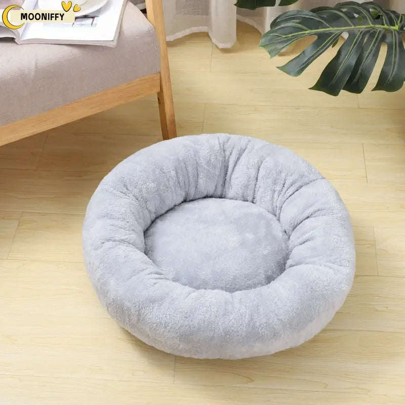 Round plush gray pet bed on a wooden floor in a cozy living room setting