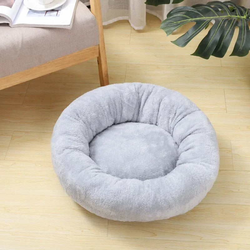 Soft round grey pet bed on light wood floor in cozy living room setting