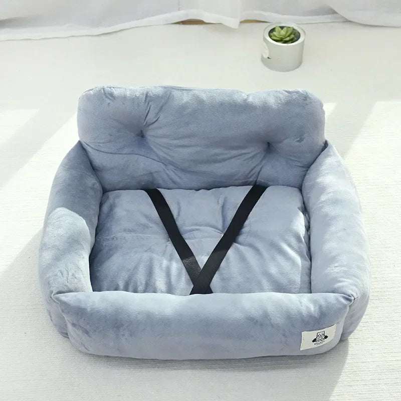 Plush light gray pet bed with high sides, black safety strap, and soft cushion.