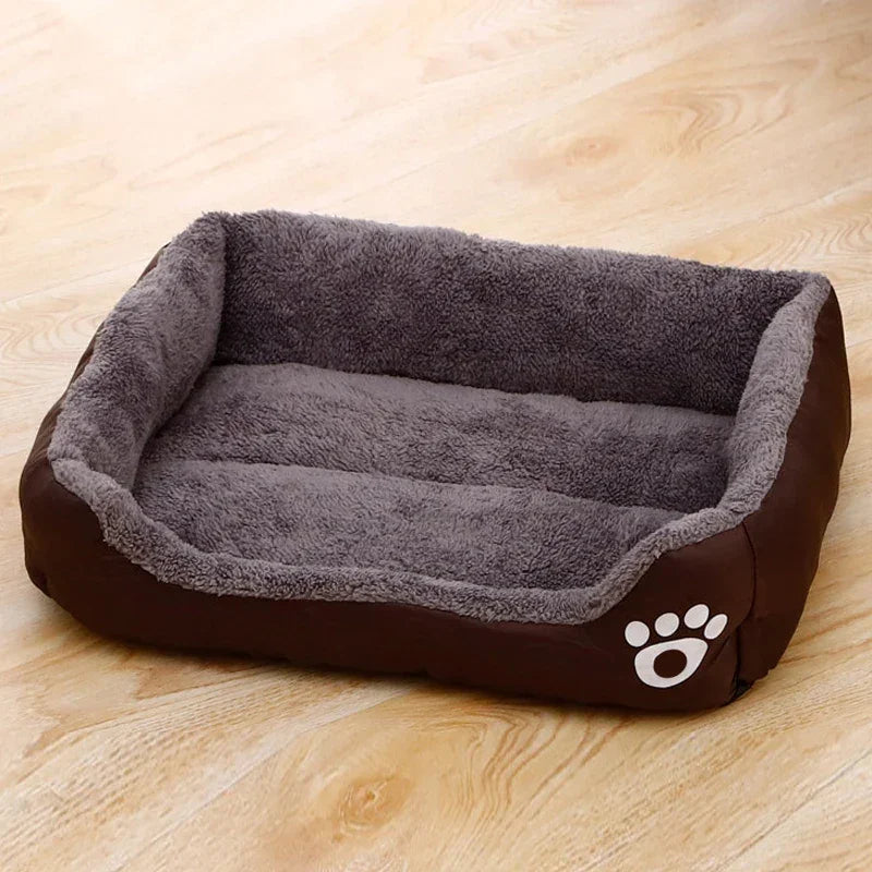 Plush rectangular brown and gray pet bed with paw print on wooden floor