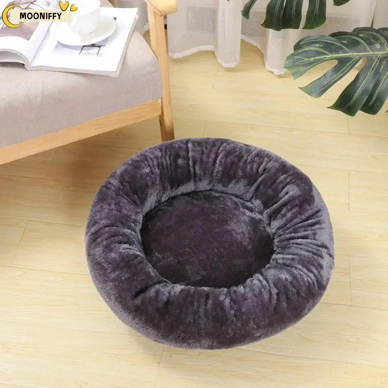 Plush round dark gray pet bed in a cozy living room setting on wooden floor